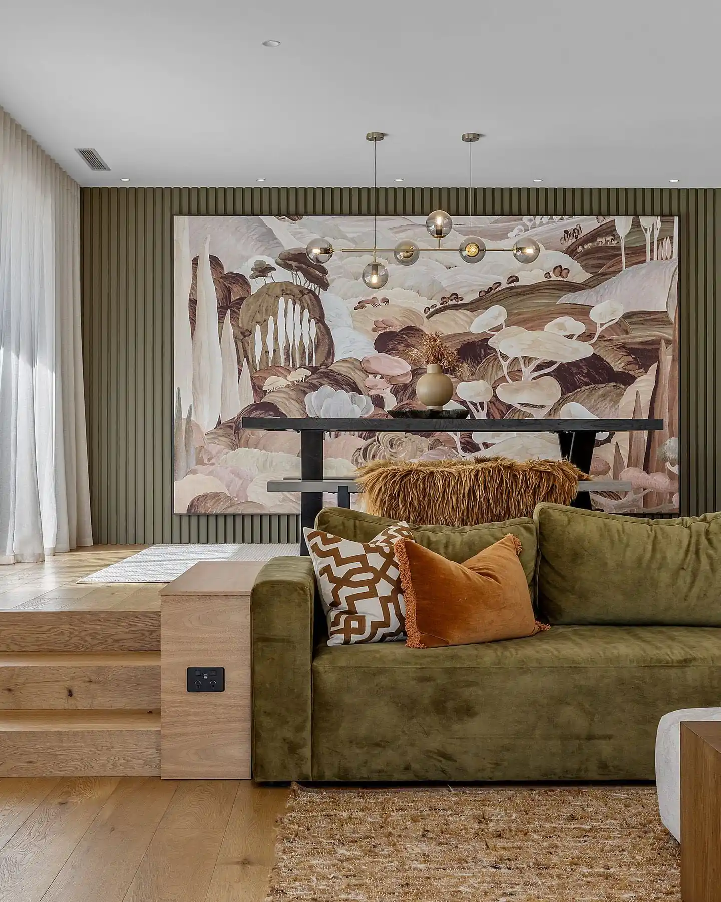 Freshly painted living room with olive panelling and a mural feature wall