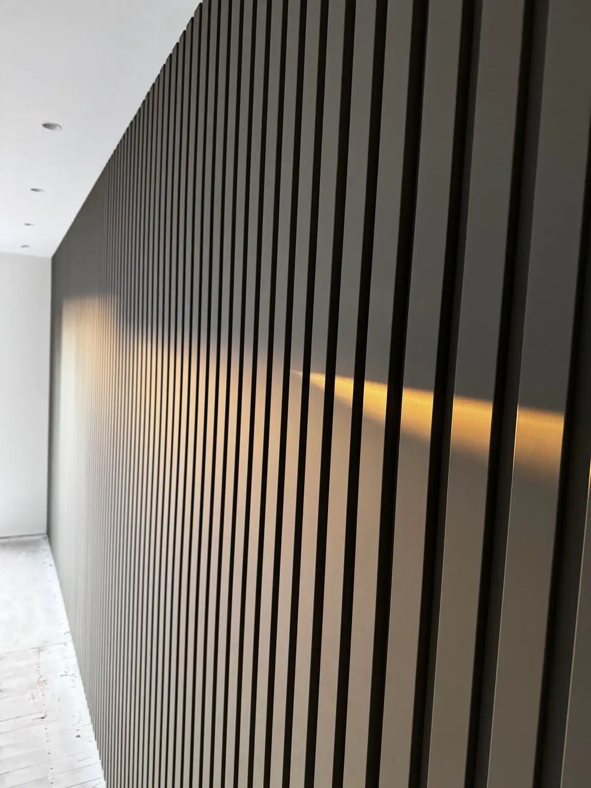 Close-up of the dark vertical slats on the curved feature wall