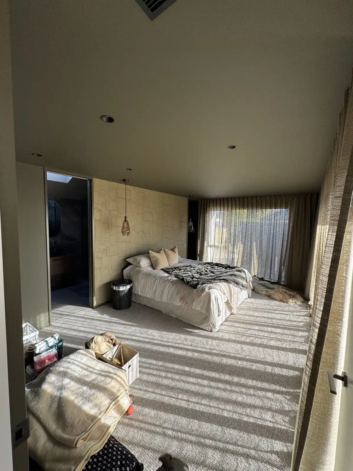 Bedroom with olive ceiling, textured wall covering and afternoon light
