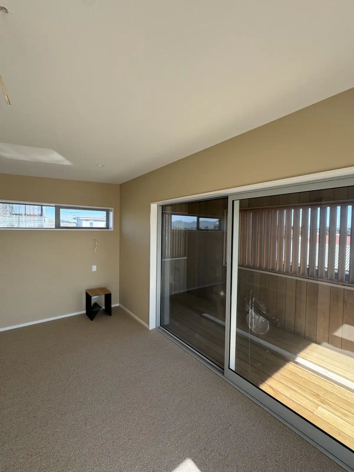 Cream bedroom with sliding doors out to the deck