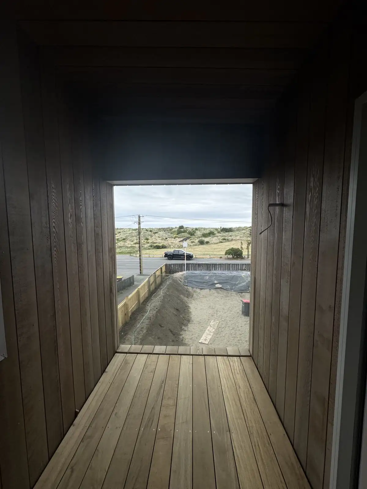 Dark-stained timber entry looking out to the street