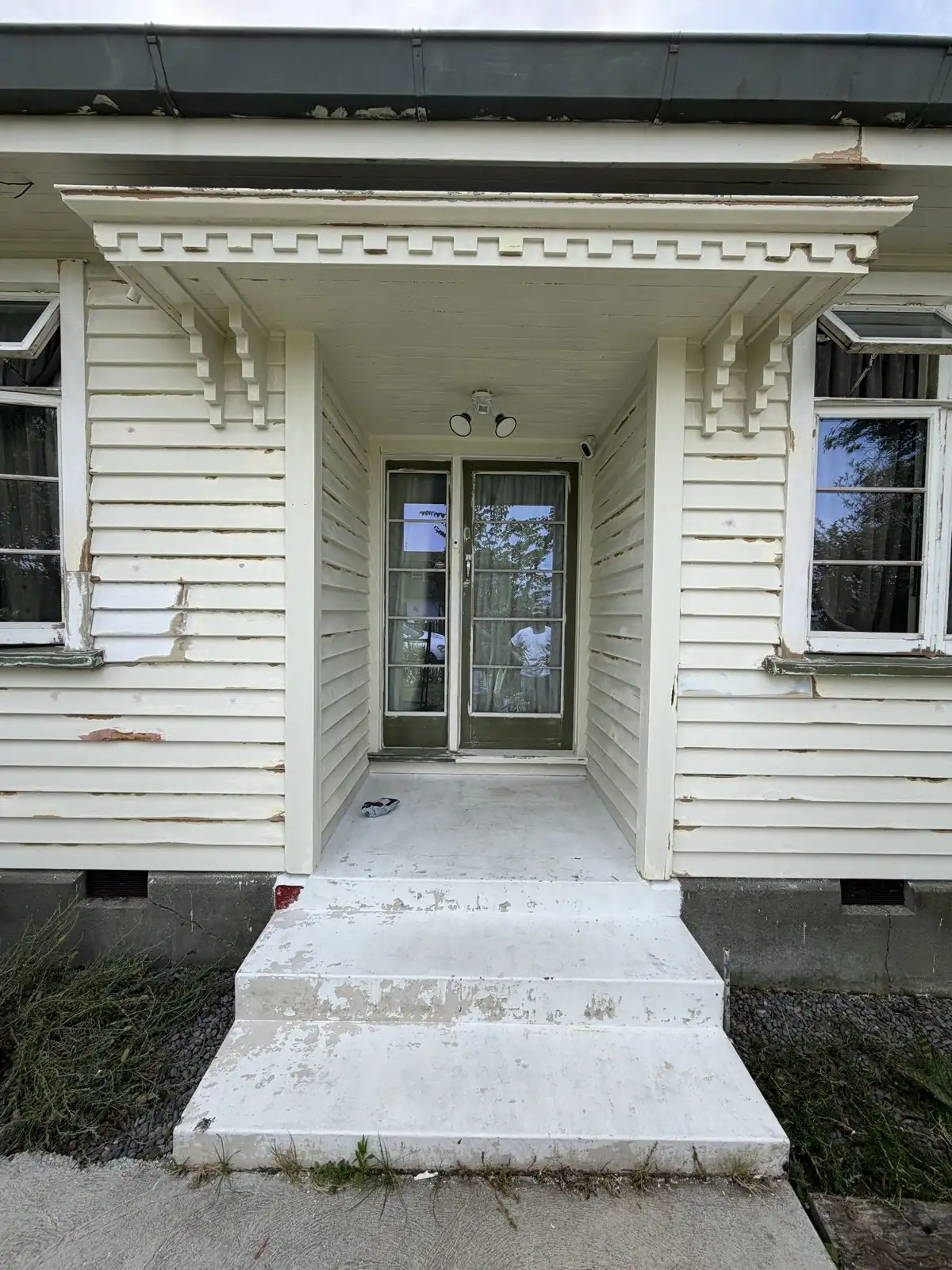 The front porch before painting, with flaking cream weatherboards