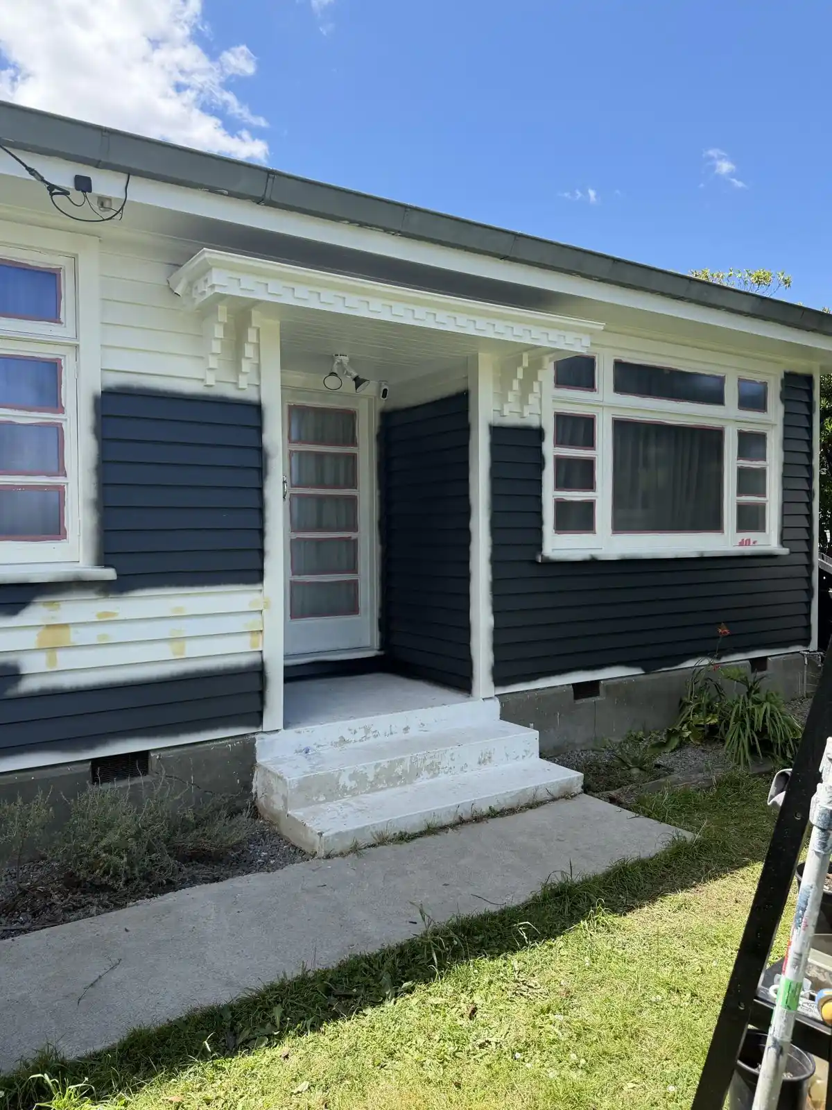 Front of the house part-way through, cream on one side and charcoal on the other