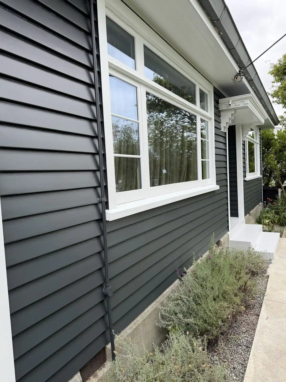 Corner window in white against the dark weatherboards