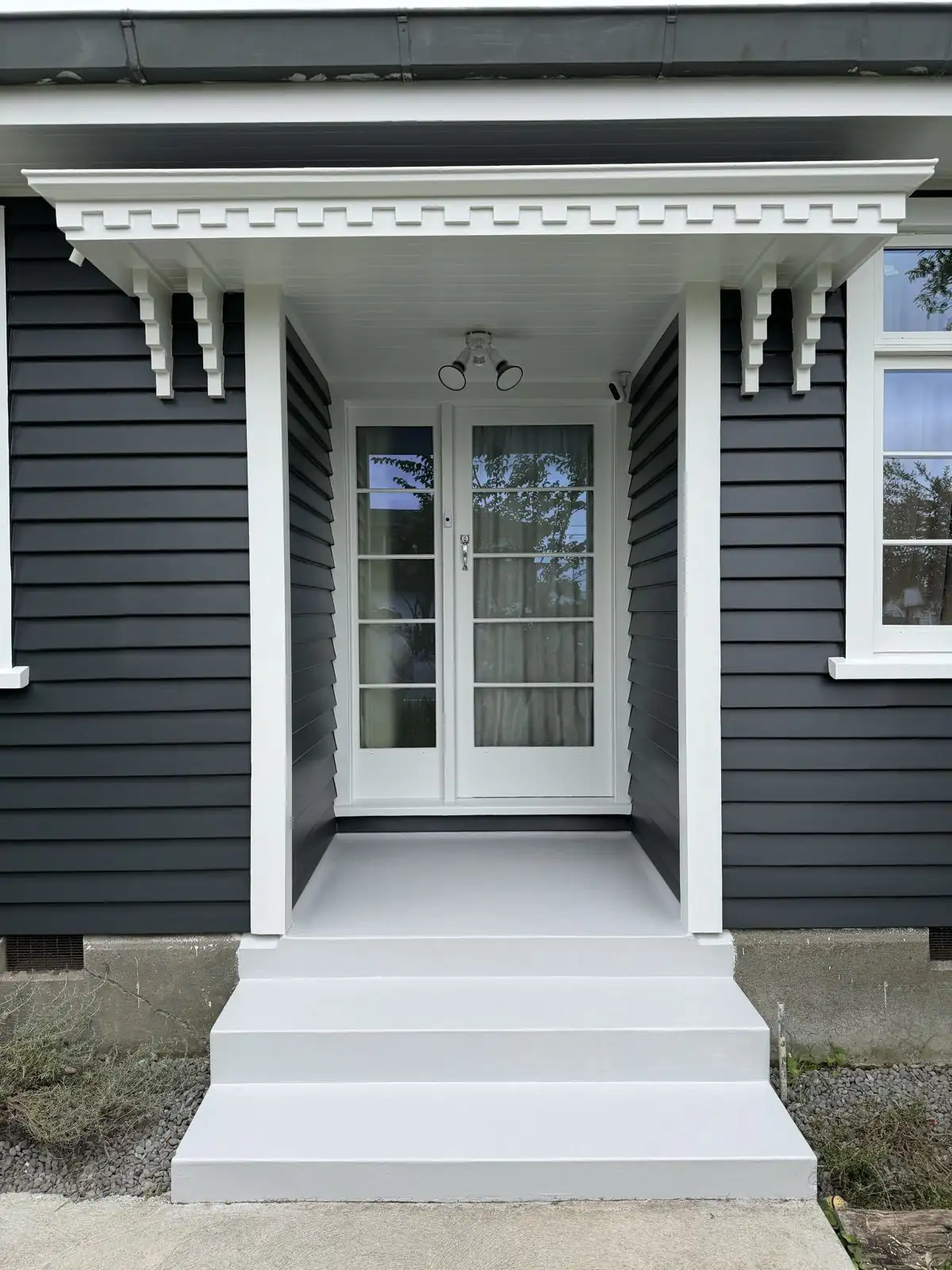 The same front porch after painting, in charcoal with white trims