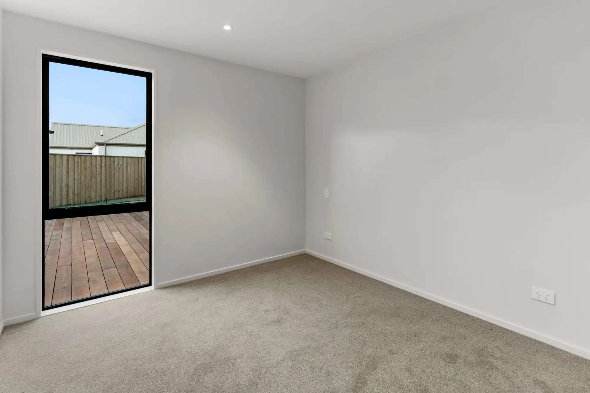 Bedroom with a glazed door opening onto a timber deck