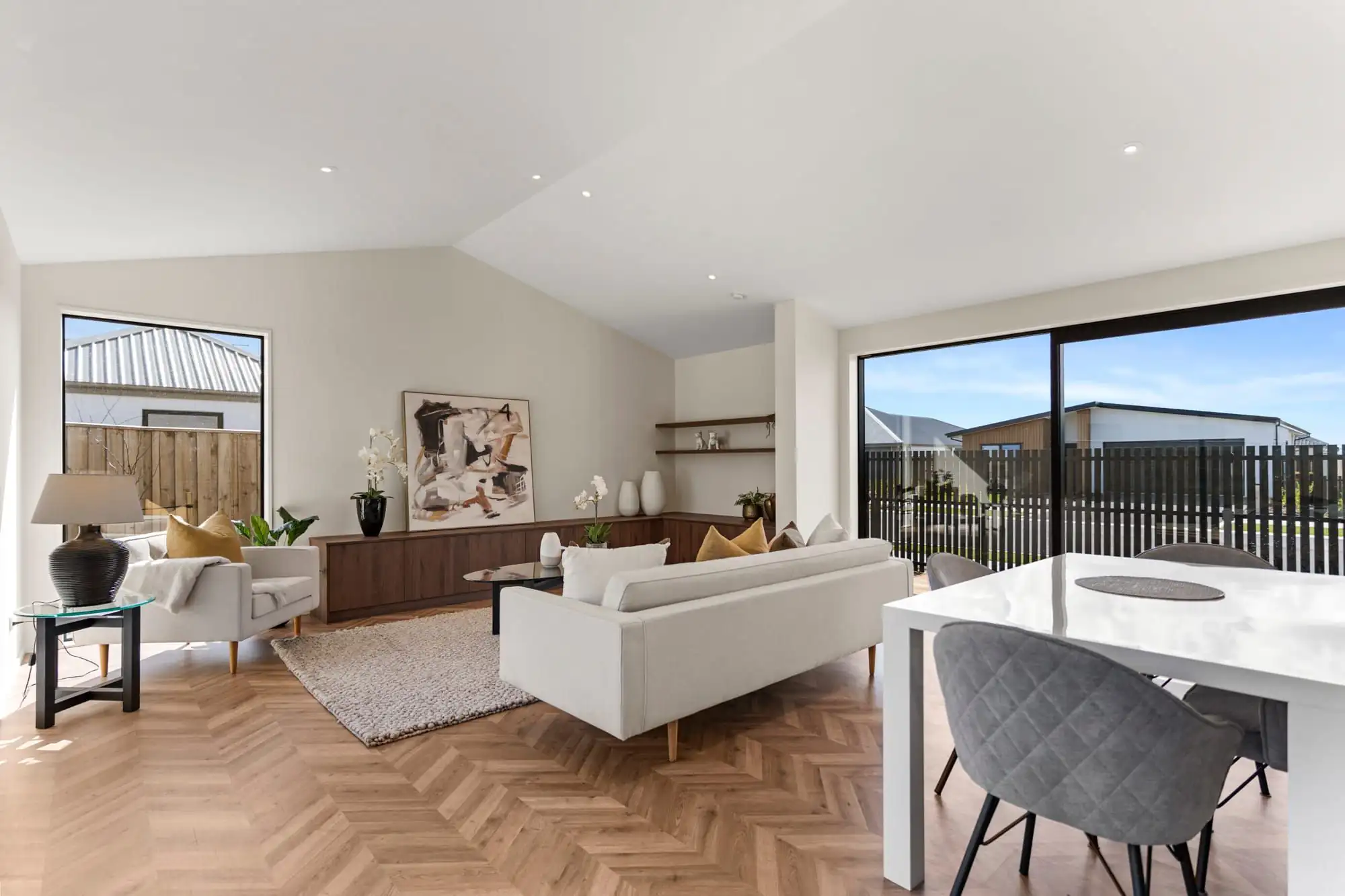 Open-plan living and dining area under a raked white ceiling
