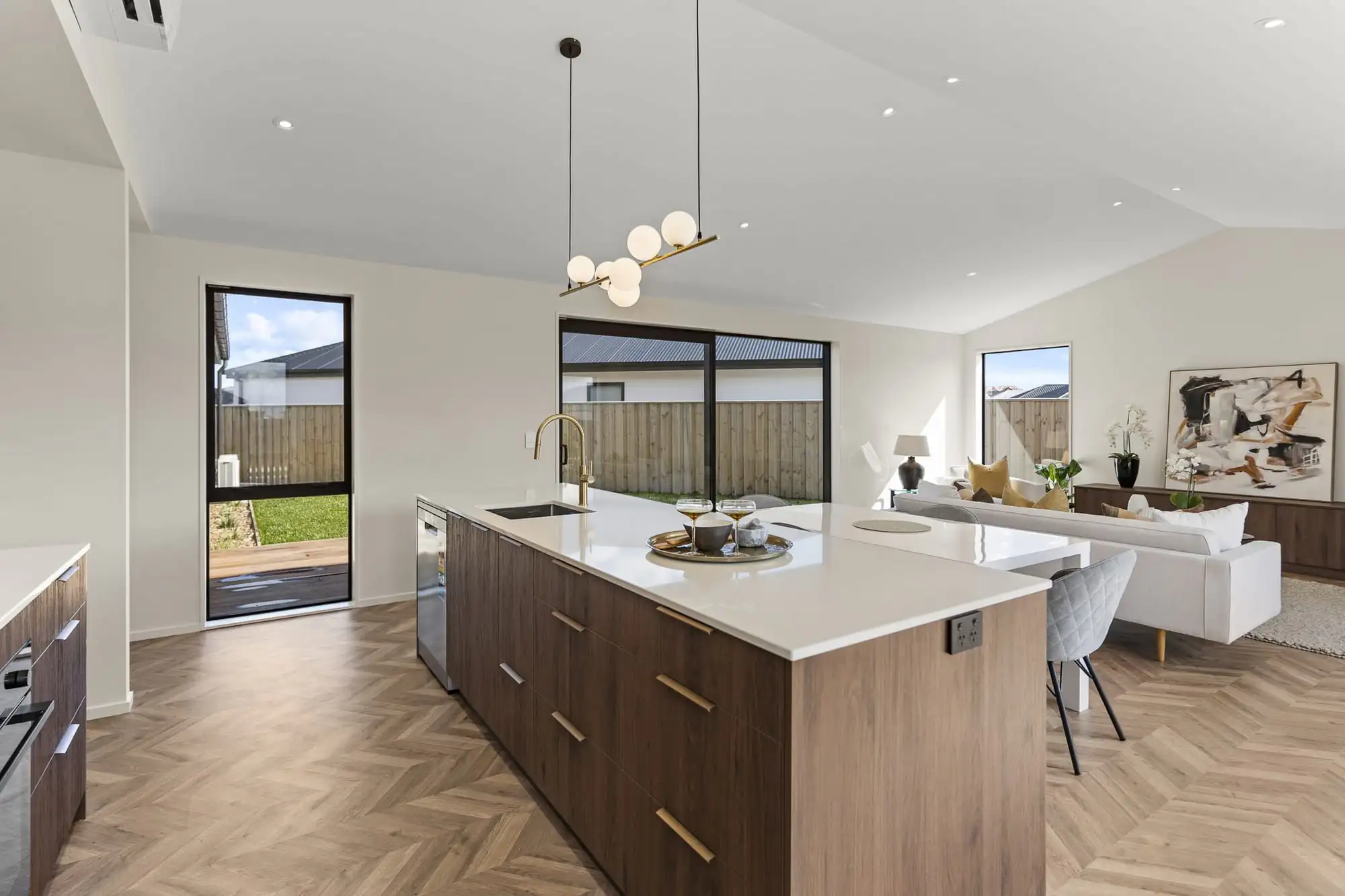 Kitchen island with the living area and windows beyond
