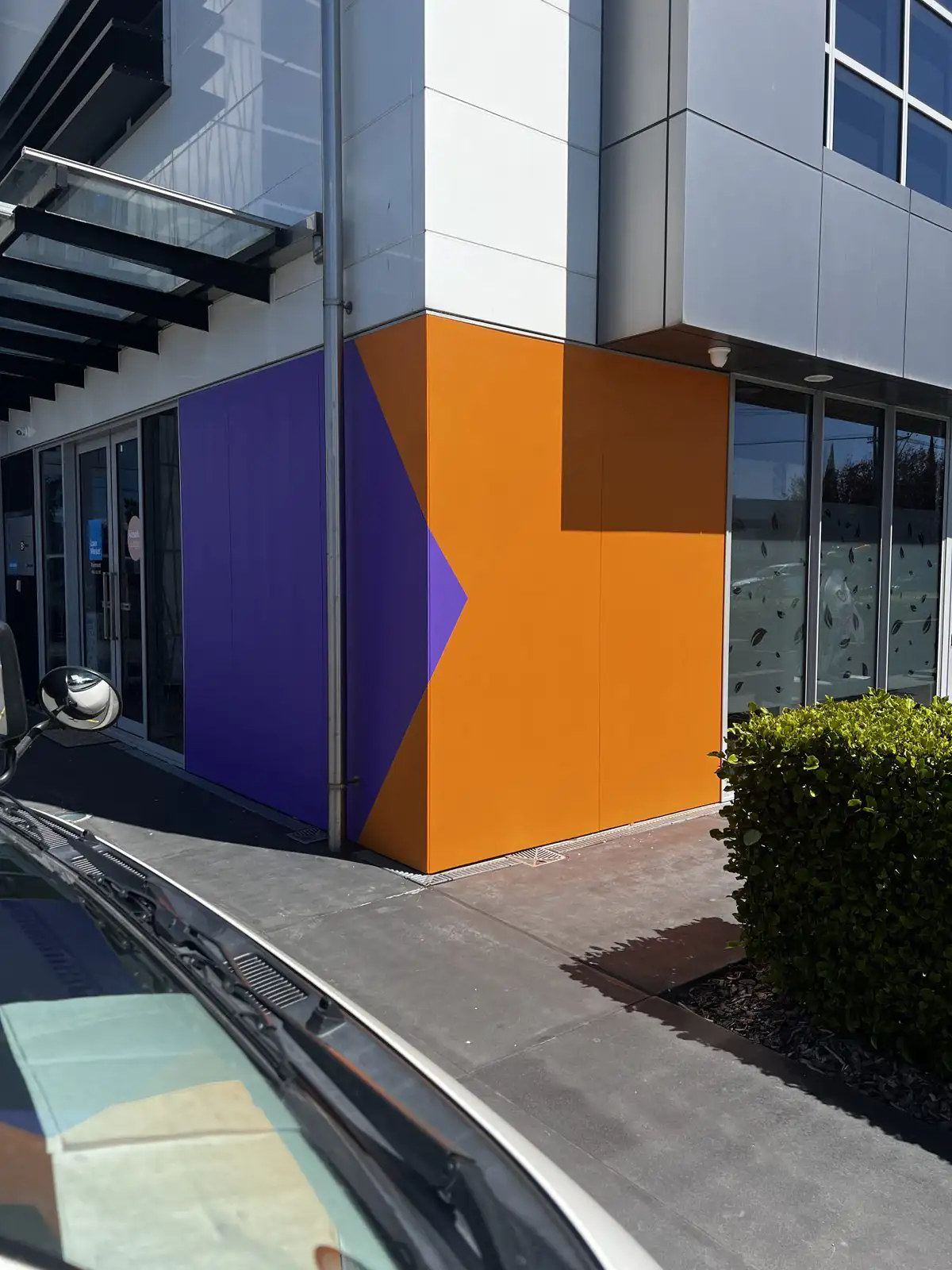 Bold orange and purple feature colours on the corner of a commercial building