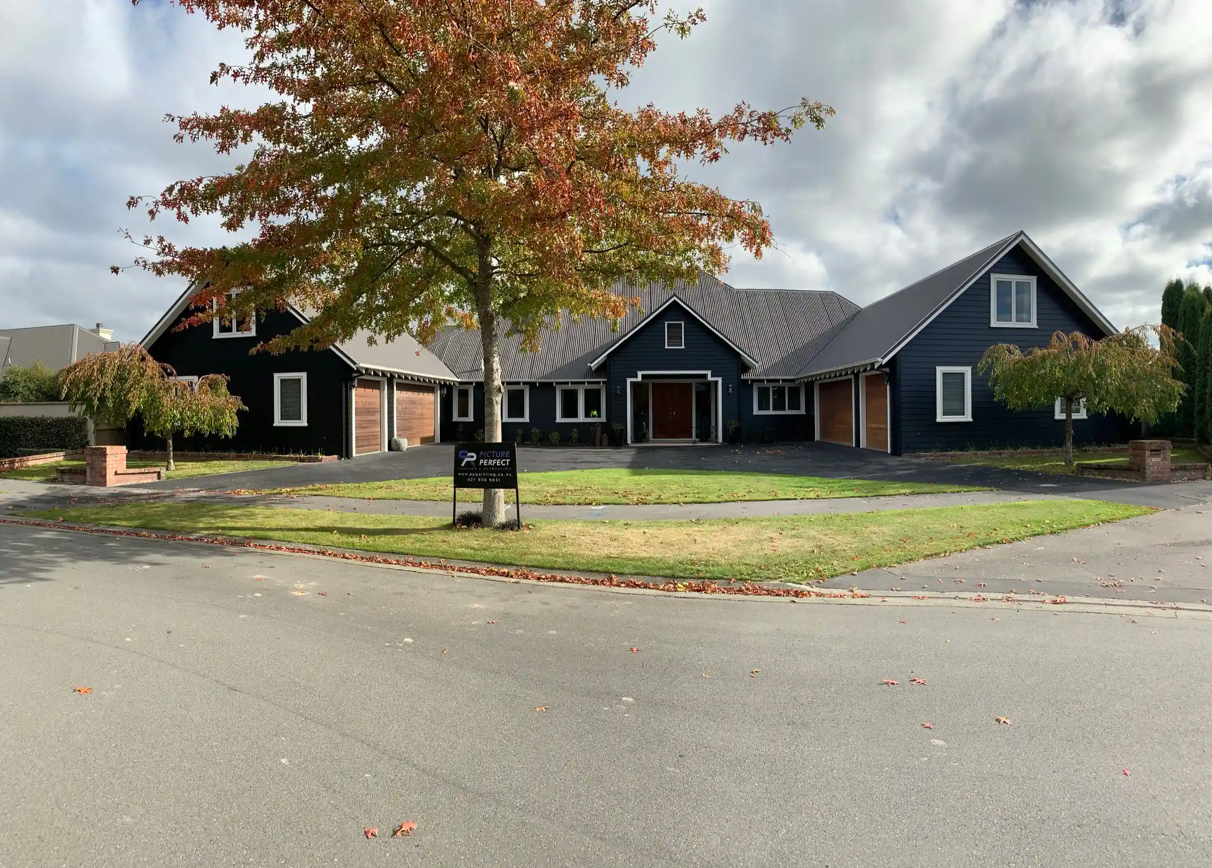 Charcoal gabled homes with long-run iron roofs on a Christchurch street